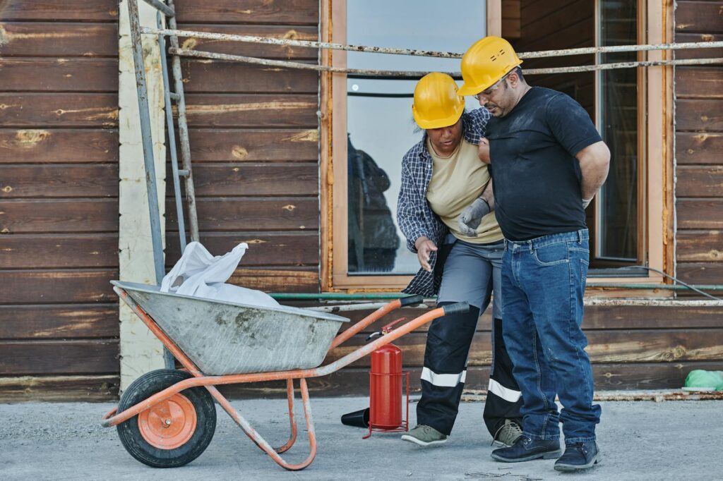 Workers compensation attorney Denver CO  construction workers assisting injured coworker at job site